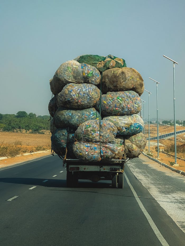 A large truck carrying massive sacks of plastic bottles on a highway in Nigeria, showcasing recycling efforts.